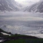 A serene glacial lake in the Eastern Himalayas surrounded by snow-capped peaks
